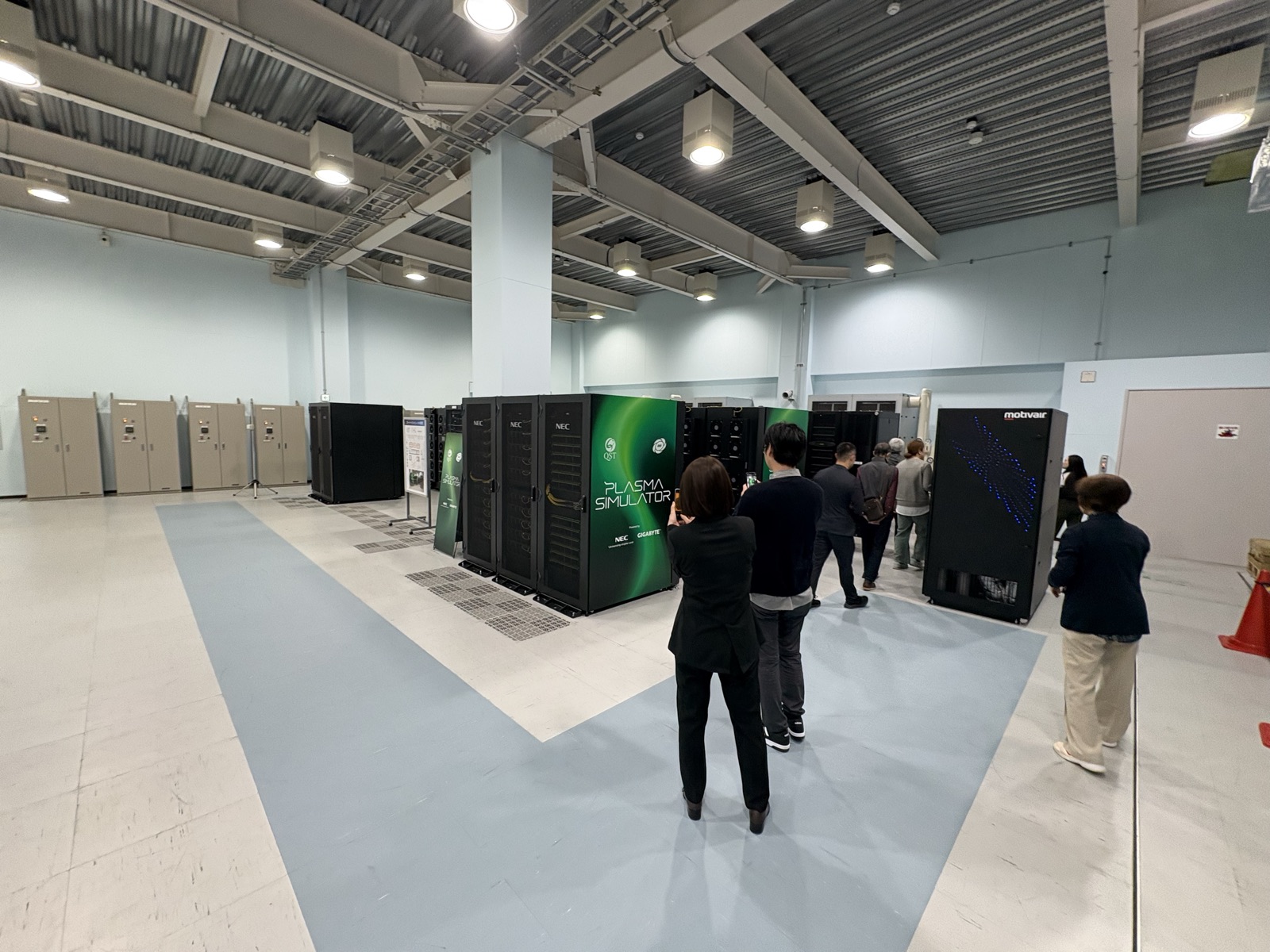 研究所のホールに並ぶ黒いスーパーコンピュータのラック