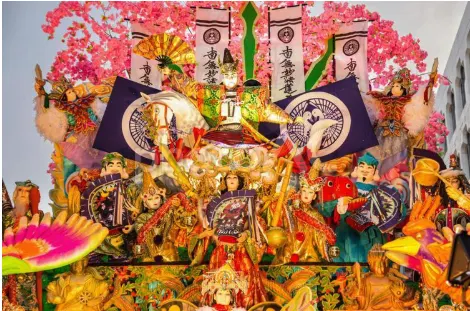 桜色の飾りを背に、武者人形が並ぶ八戸三社大祭の豪華な山車